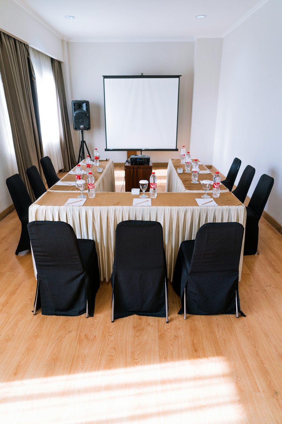 Conference room arranged with a U-shaped table and chairs.